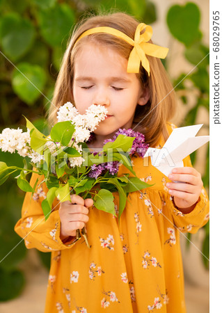 girl in a yellow dress with lilac and origami dove 68029765
