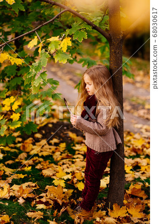 dreamy girl under tree in autumn Park with feather 68030617