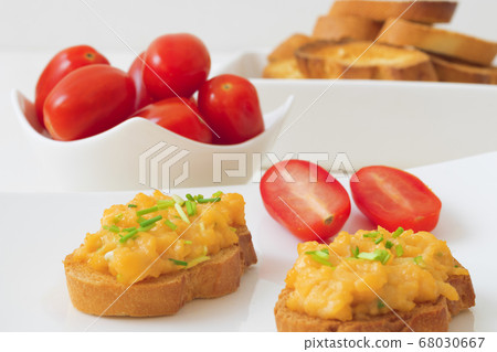 Grilled toasts and scrambled eggs, chive herbs and cherry tomatoes on white table background Grilled toasts and scrambled eggs, chive herbs and cherry tomatoes on white table background 68030667