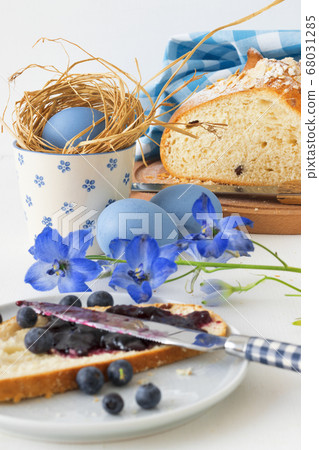 Breakfast with Easter symbols, traditional Czech pastry Mazanec, Pomlazka and eggs in blue style. Breakfast with Easter symbols, traditional Czech pastry Mazanec, Pomlazka and eggs in blue style. 68031285