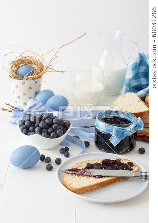 Breakfast with Easter symbols, traditional Czech pastry Mazanec, Pomlazka and eggs in blue style. Breakfast with Easter symbols, traditional Czech pastry Mazanec, Pomlazka and eggs in blue style. 68031286