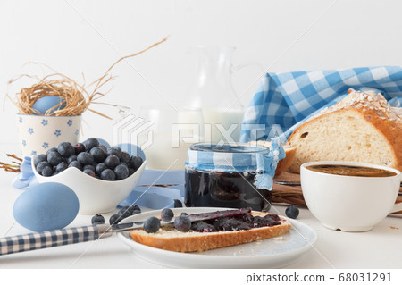 Breakfast with Easter symbols, traditional Czech pastry Mazanec, Pomlazka and eggs in blue style. Breakfast with Easter symbols, traditional Czech pastry Mazanec, Pomlazka and eggs in blue style. 68031291
