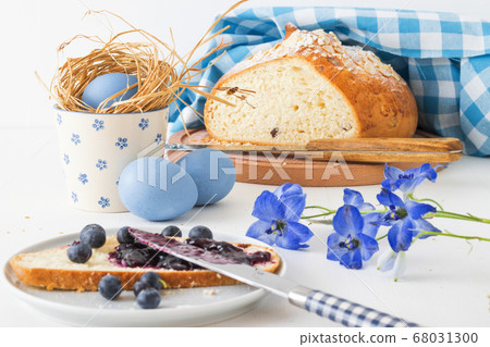 Breakfast with Easter symbols, traditional Czech pastry Mazanec, Pomlazka and eggs in blue style. Breakfast with Easter symbols, traditional Czech pastry Mazanec, Pomlazka and eggs in blue style. 68031300
