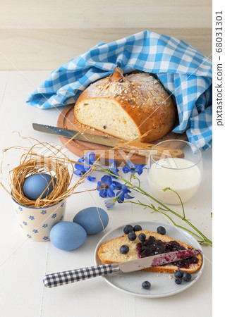 Breakfast with Easter symbols, traditional Czech pastry Mazanec, Pomlazka and eggs in blue style. Breakfast with Easter symbols, traditional Czech pastry Mazanec, Pomlazka and eggs in blue style. 68031301