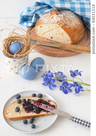 Breakfast with Easter symbols, traditional Czech pastry Mazanec, Pomlazka and eggs in blue style. Breakfast with Easter symbols, traditional Czech pastry Mazanec, Pomlazka and eggs in blue style. 68031318