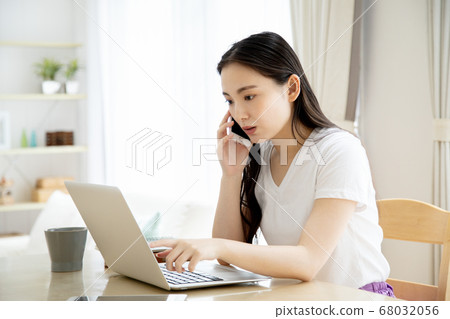 Telework image of a young woman operating a computer at home 68032056