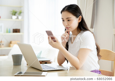 Telework image of a young woman operating a computer at home 68032066