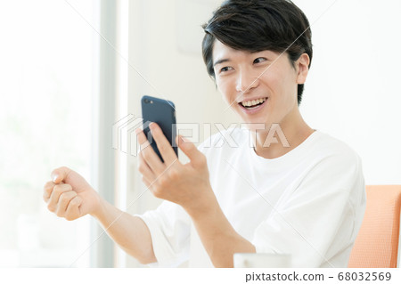 A man who communicates with a smartphone 68032569