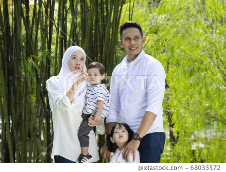 young parents spending time with their children at park during weekend 68033572