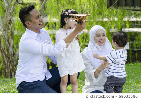 young parents spending time with their children at park during weekend 68033586