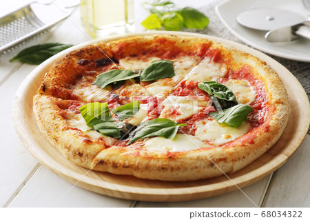 Pizza Margherita on a white table Pizza Margherita on a white table 68034322