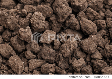 Closeup shot of Soil texture, cultivated dirt, earth, ground, brown land background. Clods of earth in a plowed field in preparation for the next planting. for use organic gardening, agriculture. 68034854