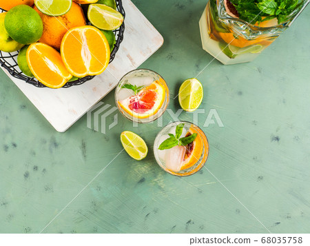 Fresh summer citrus drink with ice on green Fresh summer citrus drink with ice on green 68035758