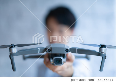 Drone business casual office man 1 person business talk aerial view window near window handheld hobby airplane 68036245