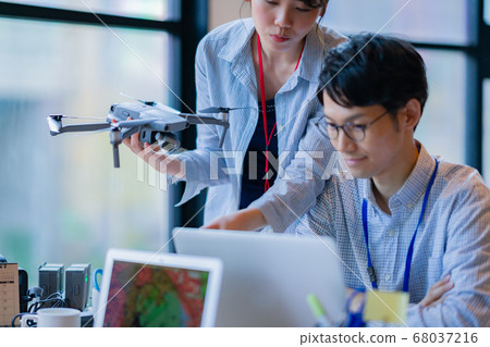 Drone business casual office two male and female business talk aerial view aerial view window hand control hobby flight Drone business casual office two male and female business talk aerial view aerial view window hand control hobby flight 68037216