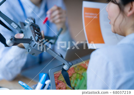 Drone business casual office two male and female business talk aerial view aerial view window hand control hobby flight 68037219