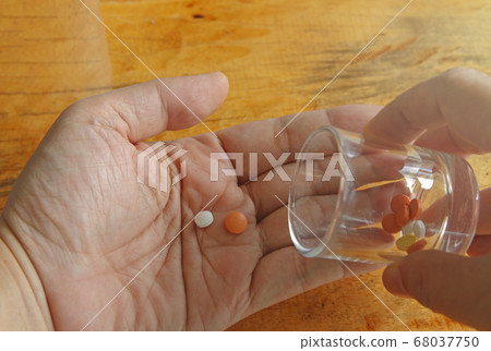 a hands holding Medicine pills or capsules in box,Pharmaceutical medicament, cure in container for health. 68037750