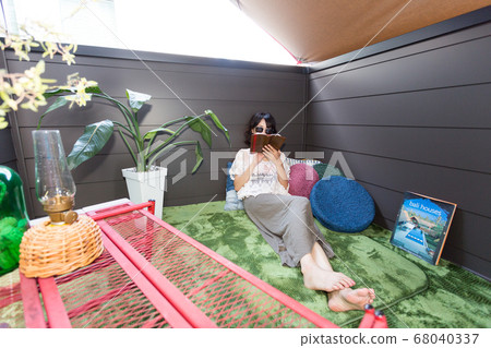 Woman reading at the veranda camp (bellamping) 68040337