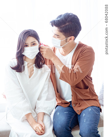 Young asian couple wearing surgical mask and using Ear thermometer Young asian couple wearing surgical mask and using Ear thermometer 68042088