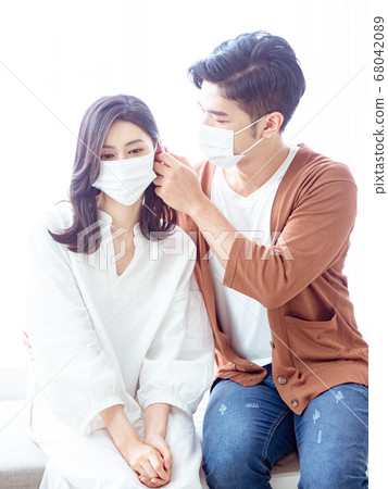 Young asian couple wearing surgical mask and using Ear thermometer Young asian couple wearing surgical mask and using Ear thermometer 68042089