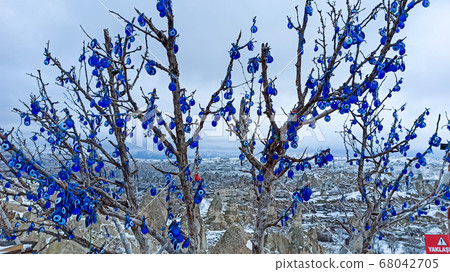Blue Evil eye charms hang on the tree in Cappadocia, Turkey Blue Evil eye charms hang on the tree in Cappadocia, Turkey 68042705