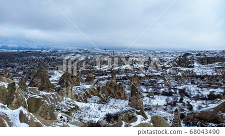 Fairy Chimneys at the valley covered with snow in winter in Goreme, Cappadocia, Turkey Fairy Chimneys at the valley covered with snow in winter in Goreme, Cappadocia, Turkey 68043490