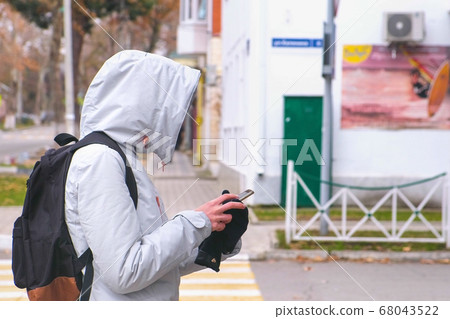 Woman got lost in the city and looking for a route using the Navigator in the mobile phone. 68043522
