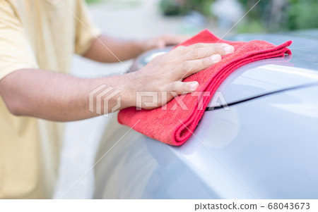 Man using red cloth to cleaning body of SUV car. Man using red cloth to cleaning body of SUV car. 68043673