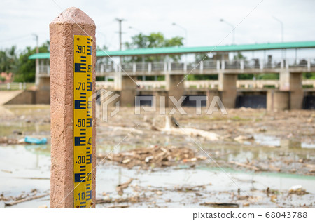 Water level gauge on the pole at the dam 68043788