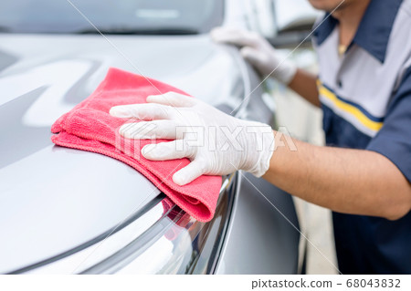 Man using red cloth to cleaning body of SUV car. Man using red cloth to cleaning body of SUV car. 68043832
