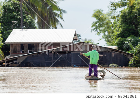 Thai man on the boat and looking to his house 68043861