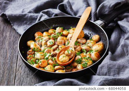Sauteed garlic white mushrooms on a pan, close-up 68044058