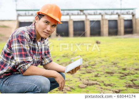 Young engineer working on site at the dam 68044174