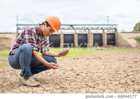Young engineer working on site at the dam 68044177