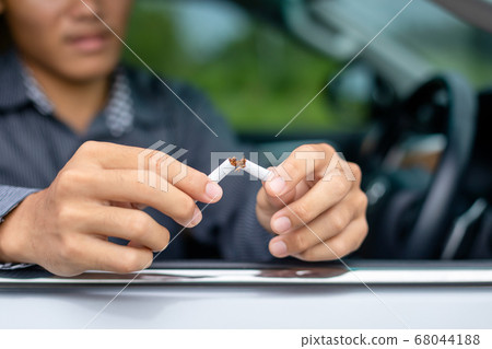 Young man sitting in the car and destroy cigarette Young man sitting in the car and destroy cigarette 68044188