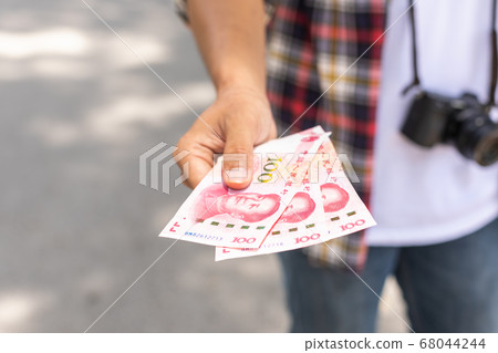 Hand of Asian tourist giving banknote and black Hand of Asian tourist giving banknote and black 68044244