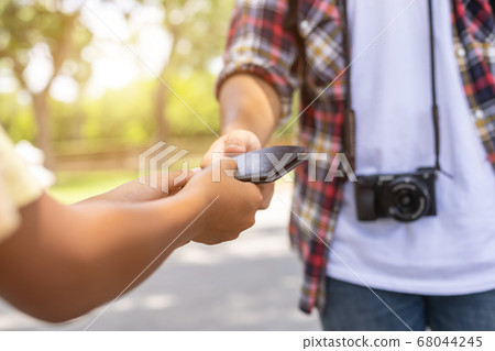Asian tourist picking up his black wallet from 68044245