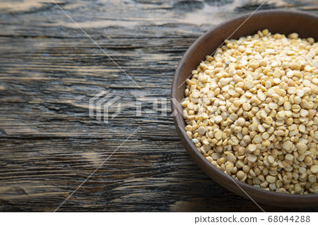 Dried yellow peas in a plate. 68044288