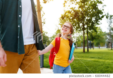 Cheerful schoolgirl walking to school with father. 68044482