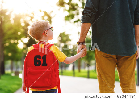 Crop man and schoolboy in park. Crop man and schoolboy in park. 68044484