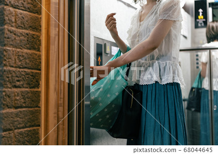 Woman using an elevator Woman using an elevator 68044645