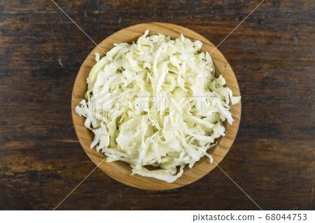 Chopped cabbage in a bowl on a wooden background. 68044753