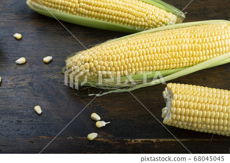 Fresh corn on cobs on rustic wooden table 68045045