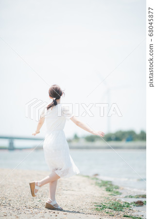 Young woman walking on the seaside Young woman walking on the seaside 68045877