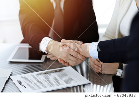 Business people shaking hands after contract signing in sunny modern office. Teamwork and handshake concept Business people shaking hands after contract signing in sunny modern office. Teamwork and handshake concept 68045938