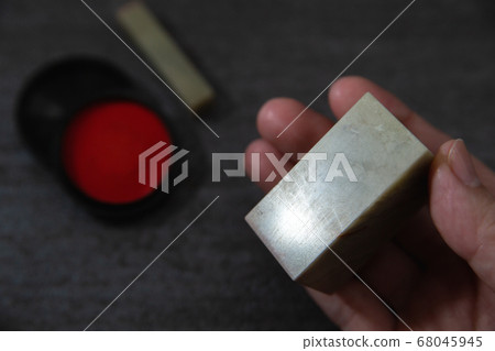 A stone carved seal with a sword. Stone carving and vermilion. A seal, seal, or signature to be stamped on a document. 68045945