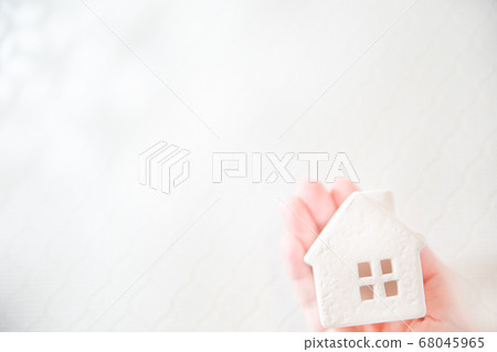 手中裹著的房子。房地產,家庭,家庭和生活的溫馨家庭形象。 手中裹著的房子。房地產,家庭,家庭和生活的溫馨家庭形象。 68045965