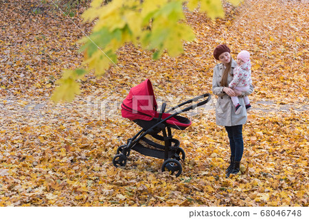 Young mother with baby Stroller walking in autumn 68046748