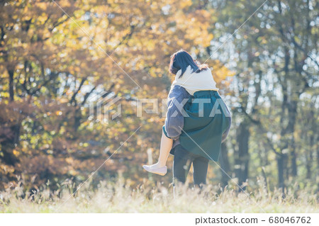 Couple piggyback ride on the meadow 68046762