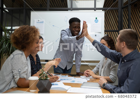 Happy diverse male designers give high five at multiracial meeting Happy diverse male designers give high five at multiracial meeting 68048372